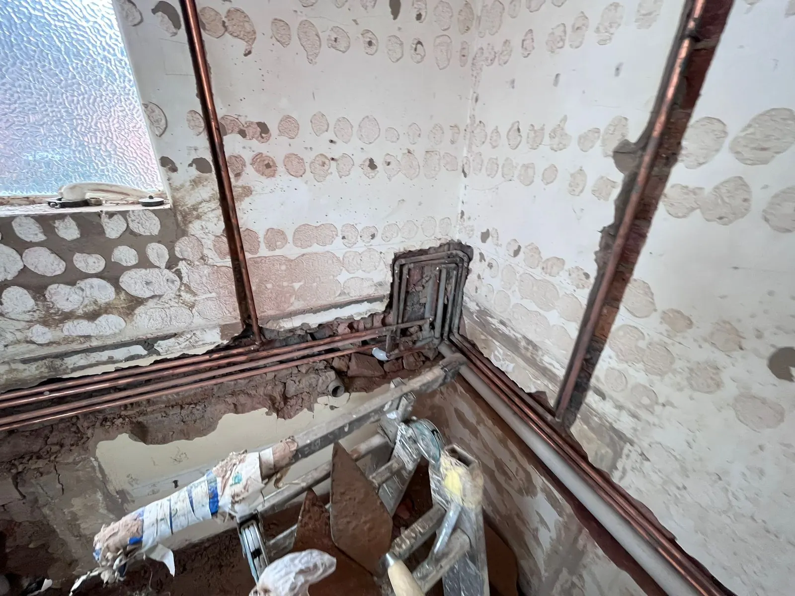 During: new copper hot and cold water pipes chased into the stripped walls