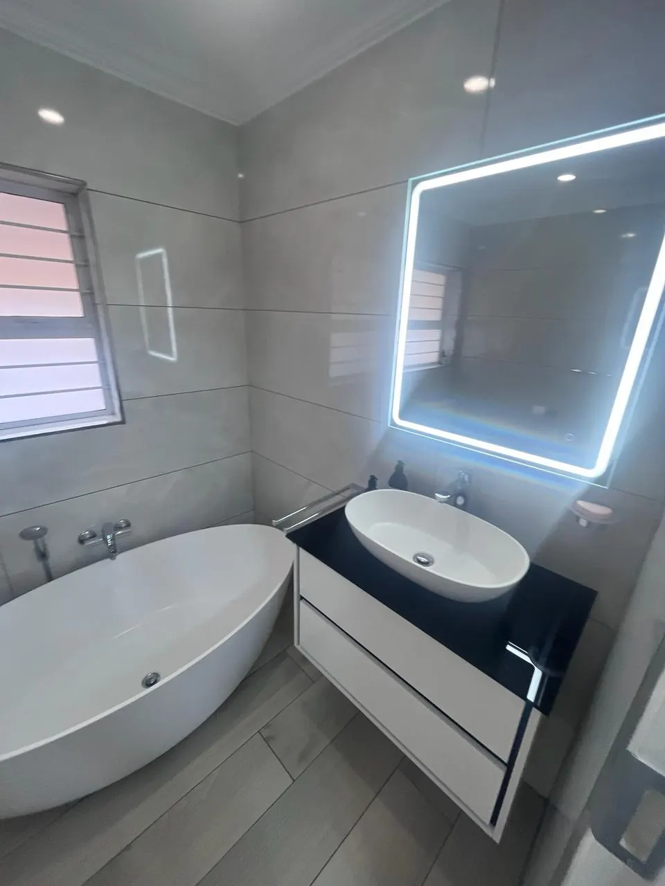 After: freestanding bath and floating vanity with LED mirror