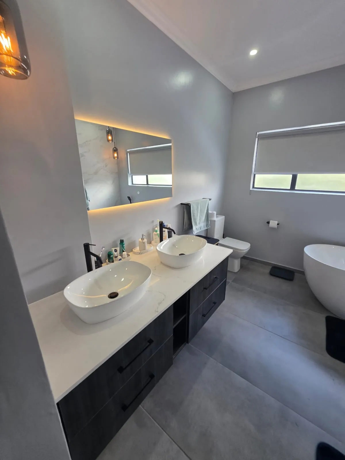 Double vanity with LED mirror, toilet and freestanding bath in the renovated main bathroom