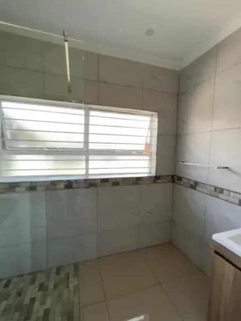 After: walk-in shower with frameless glass and mosaic shower floor, replacing the old bath