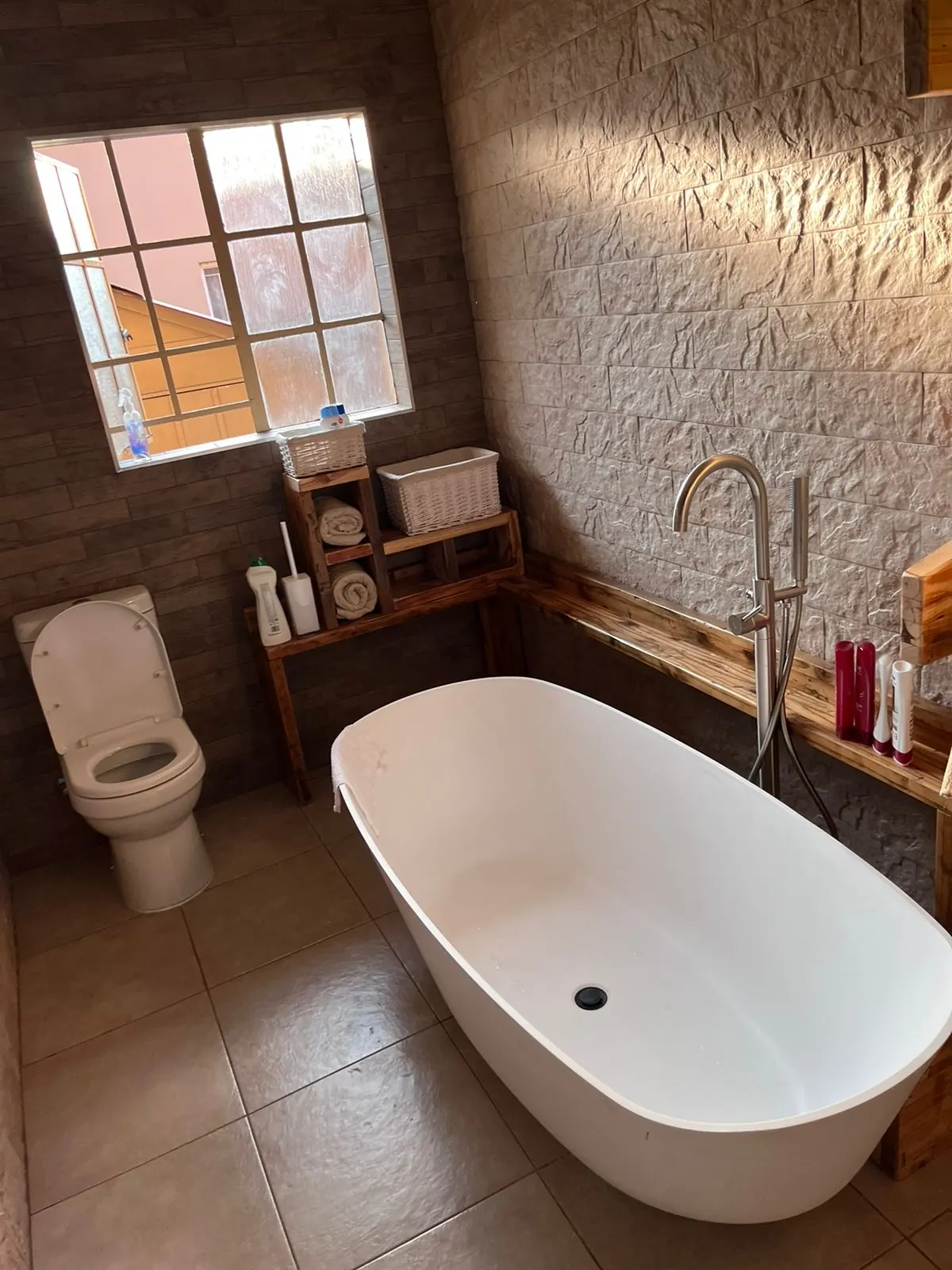 Freestanding bath and toilet against a textured feature wall