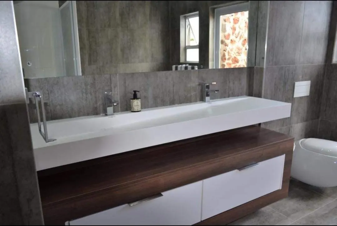 Wide white trough basin on a timber and white floating vanity