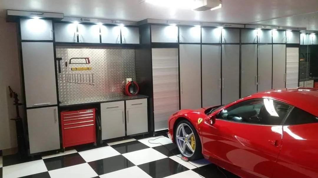 Garage fitted with full-height storage cabinets, lit top units and a workbench