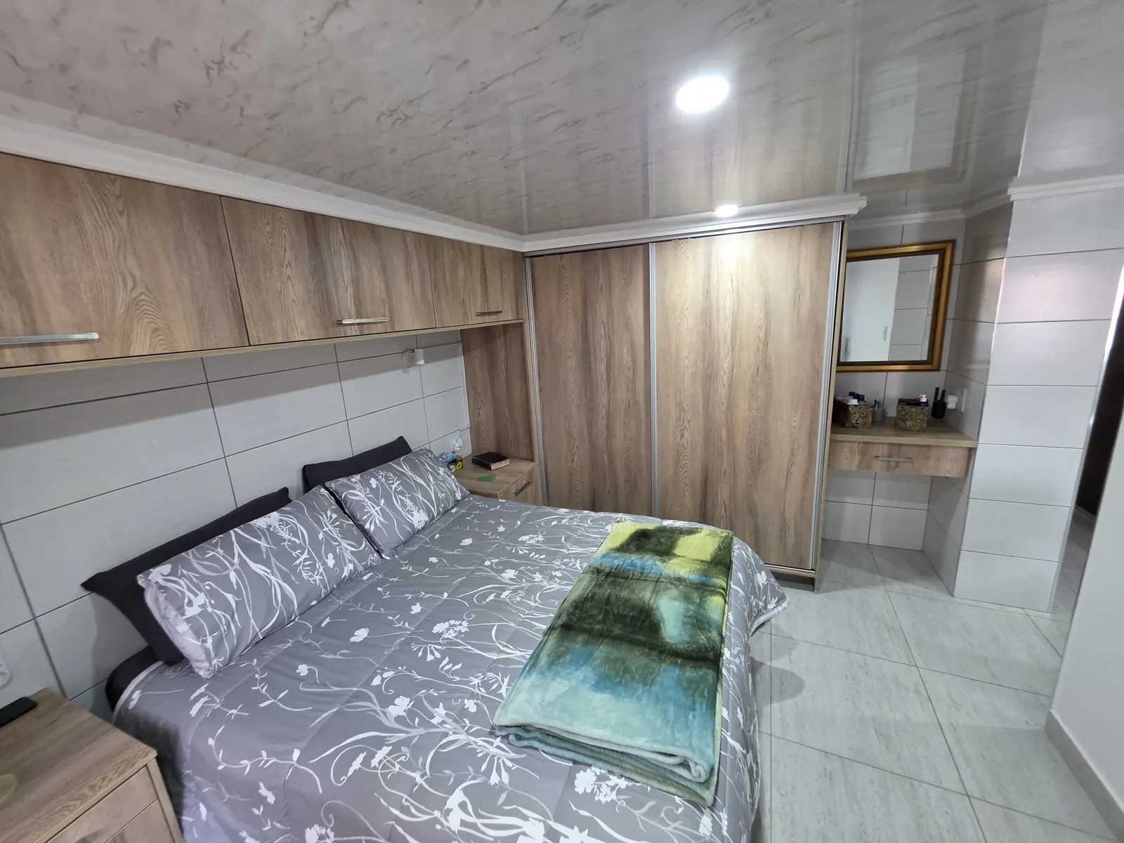 Oak-look sliding wardrobe beside a built-in dressing niche with drawer