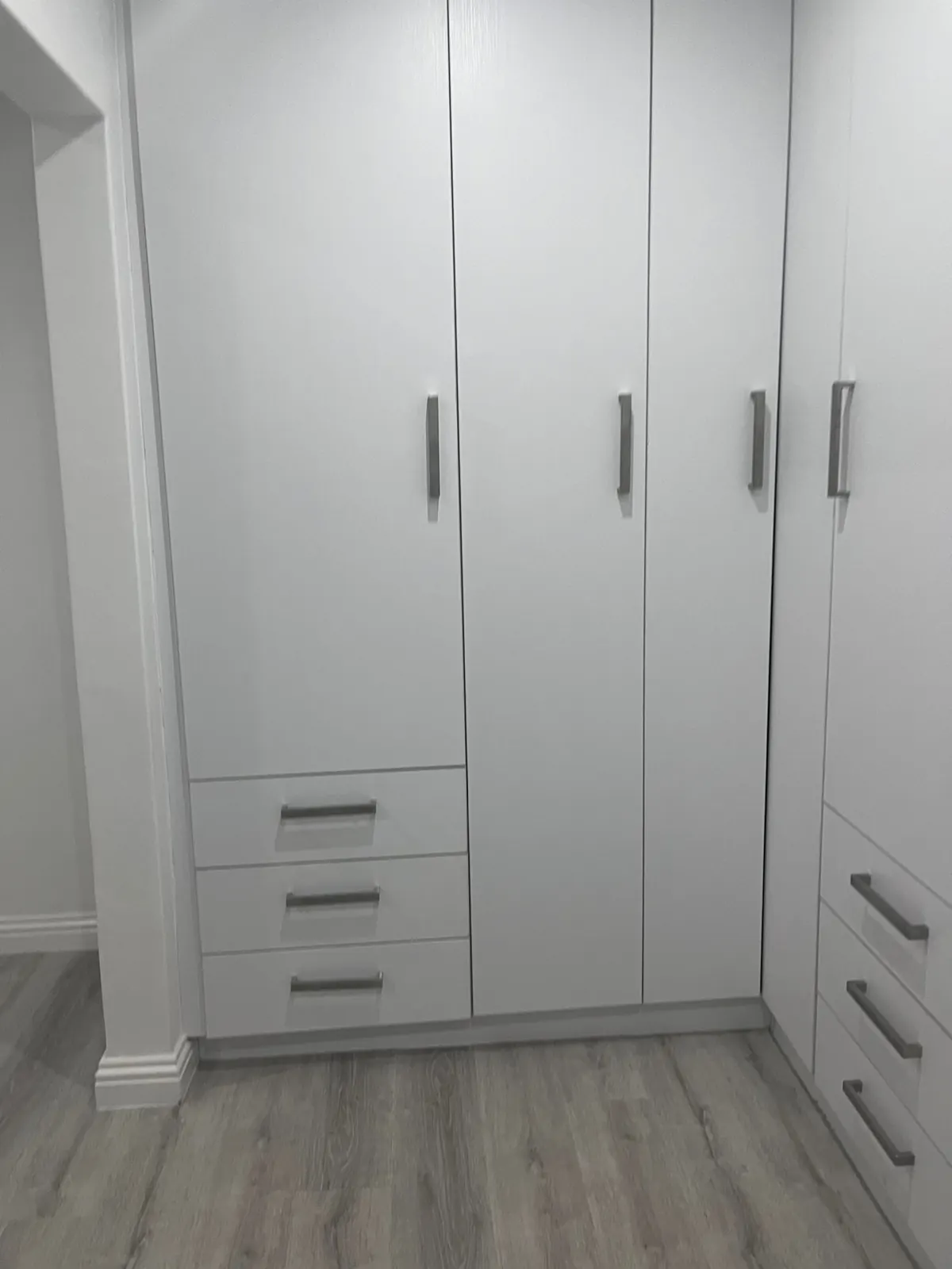 White wardrobe doors and drawers with steel handles
