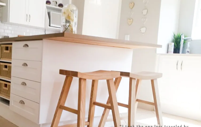 White shaker kitchen island with timber top, wicker basket drawers and timber bar stools