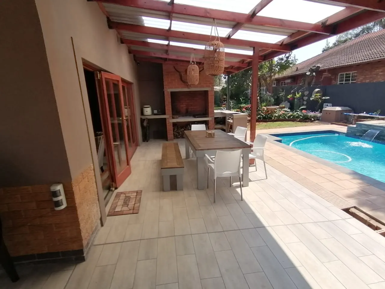 Covered patio with built-in brick braai, tiled floor and pool