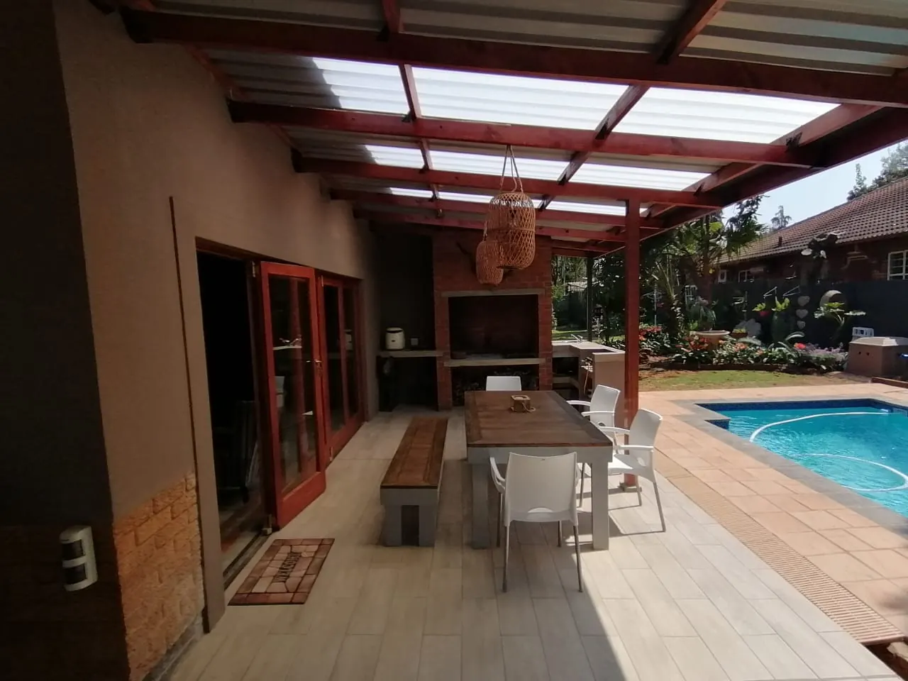 Patio with built-in braai, dining area and timber-framed roof