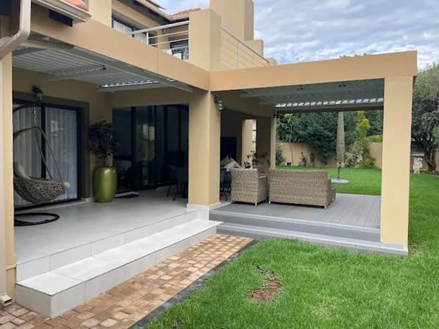 Patio with an adjustable louvre roof, tiled steps and a composite deck
