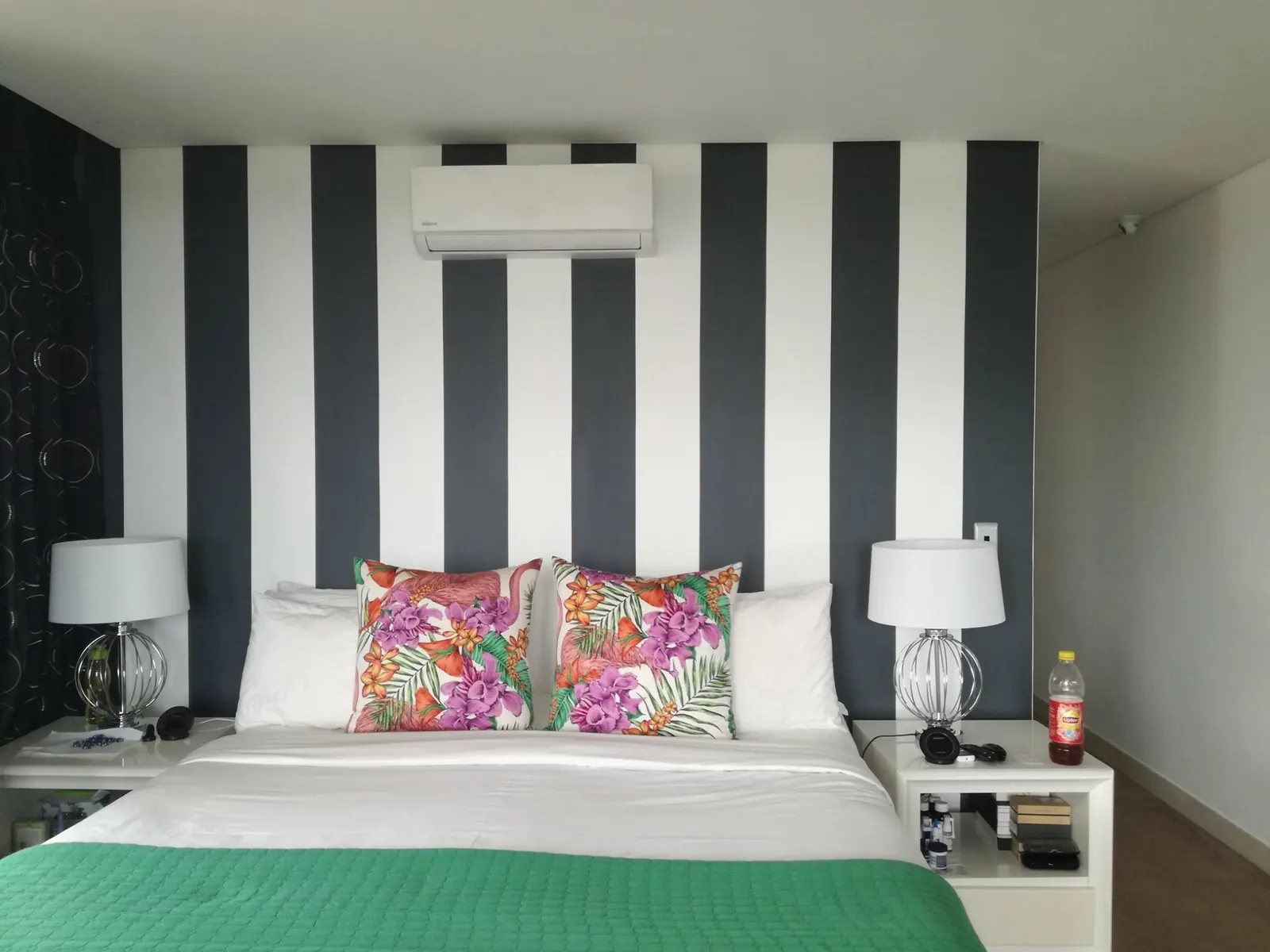 Bedroom with a painted black and white striped feature wall and built-in side tables