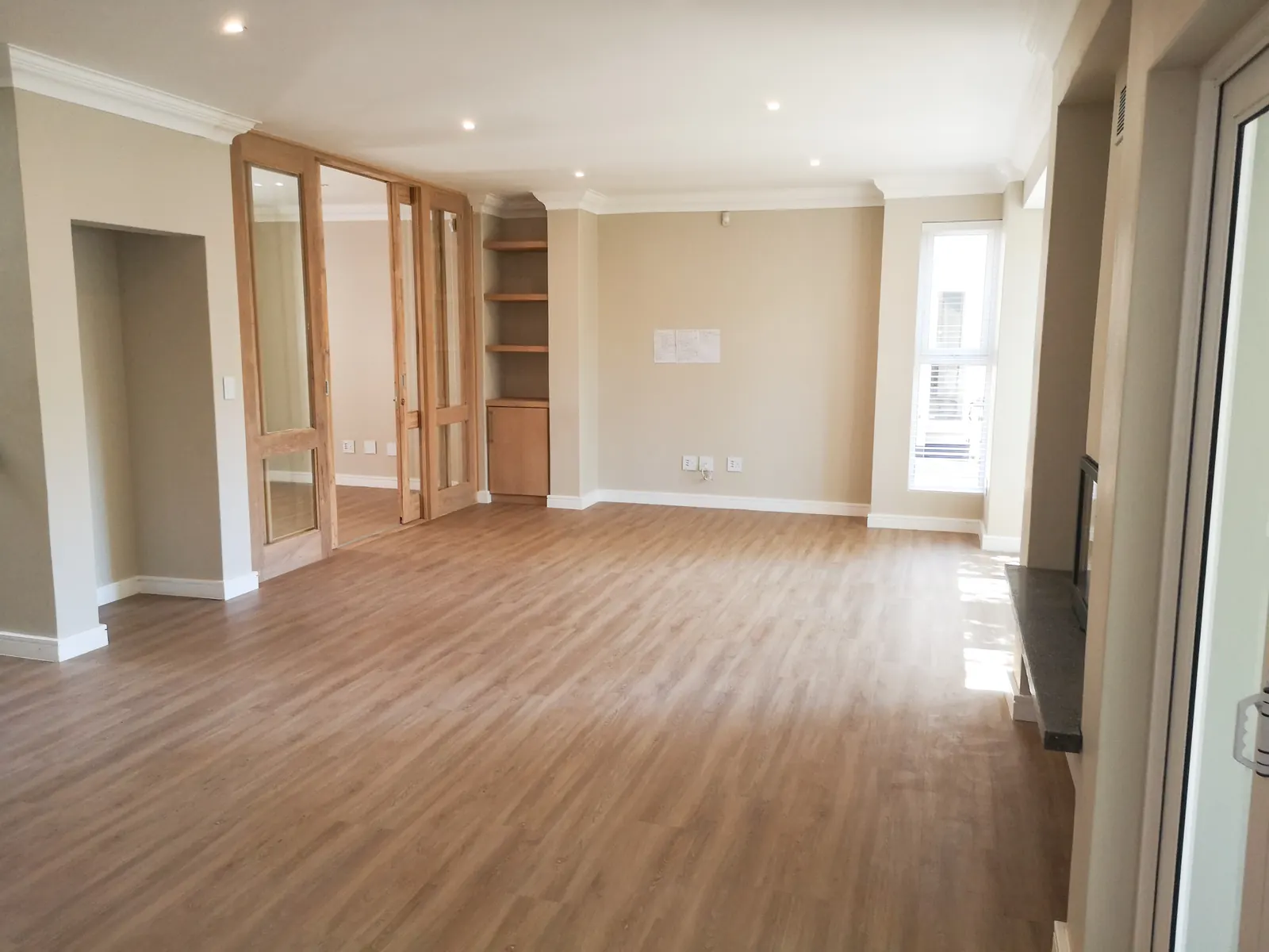 Renovated open living room with laminate flooring, cornices and timber sliding doors