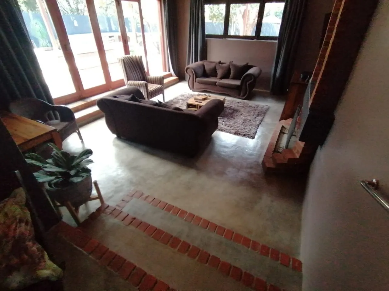 Renovated lounge with timber sliding doors, tiled steps and a feature brick wall