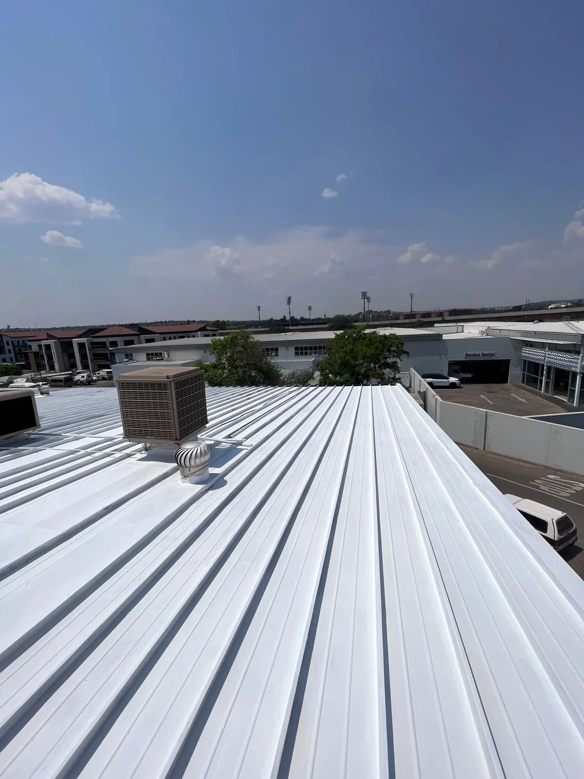 Completed white roof coating around rooftop air coolers and whirlybird vents