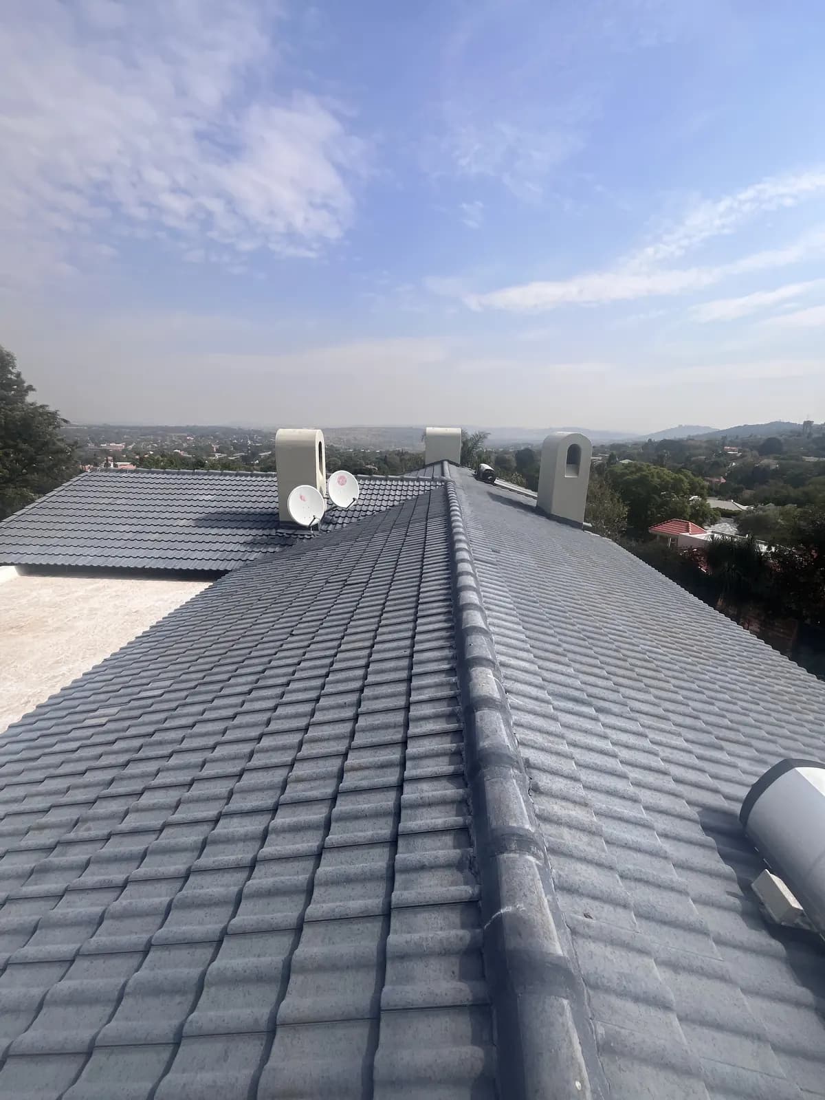 Restored grey concrete tile roof with re-bedded ridge caps